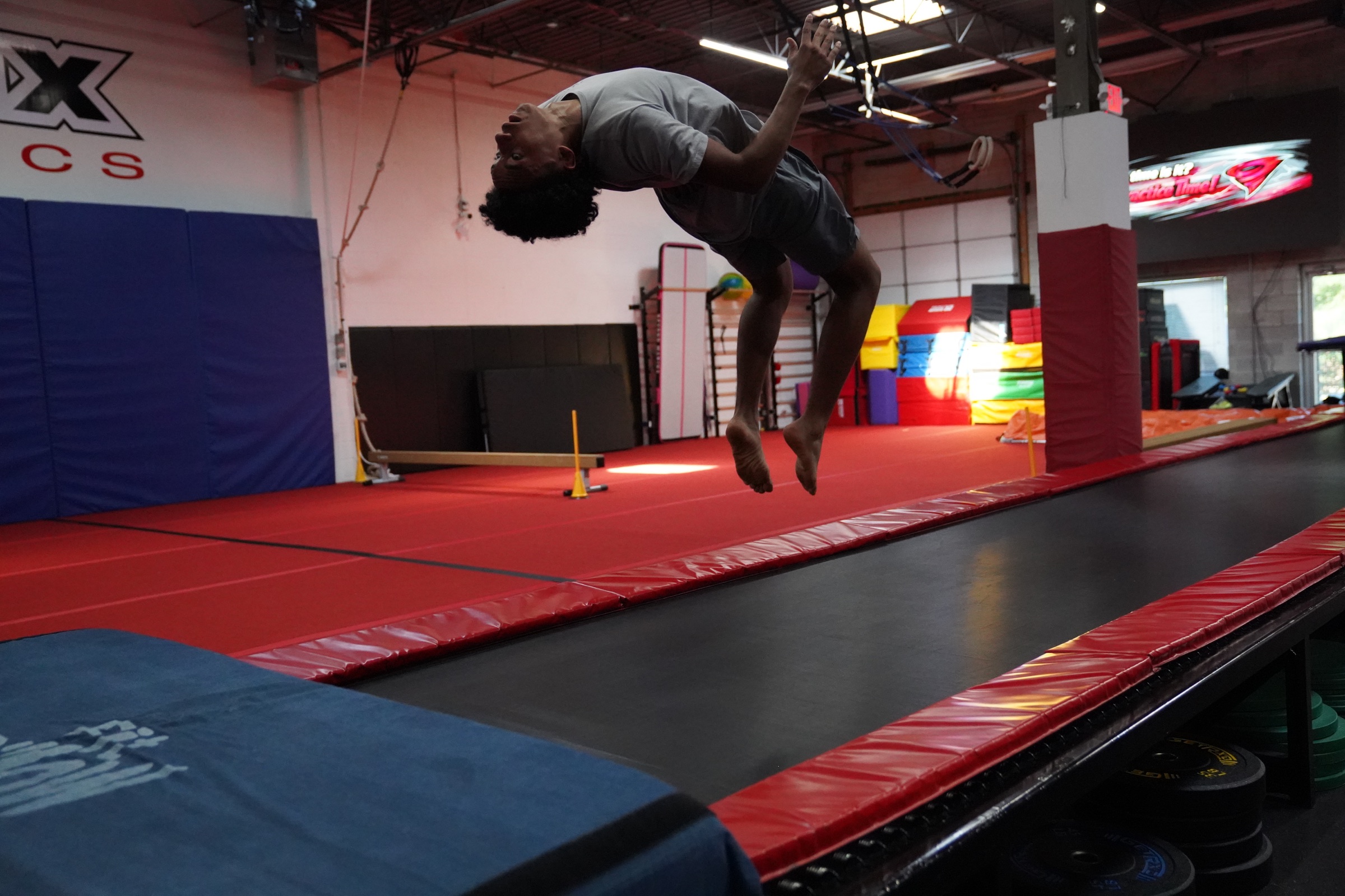 A Vortex athlete performing a tumbling skill above the power tumbling track